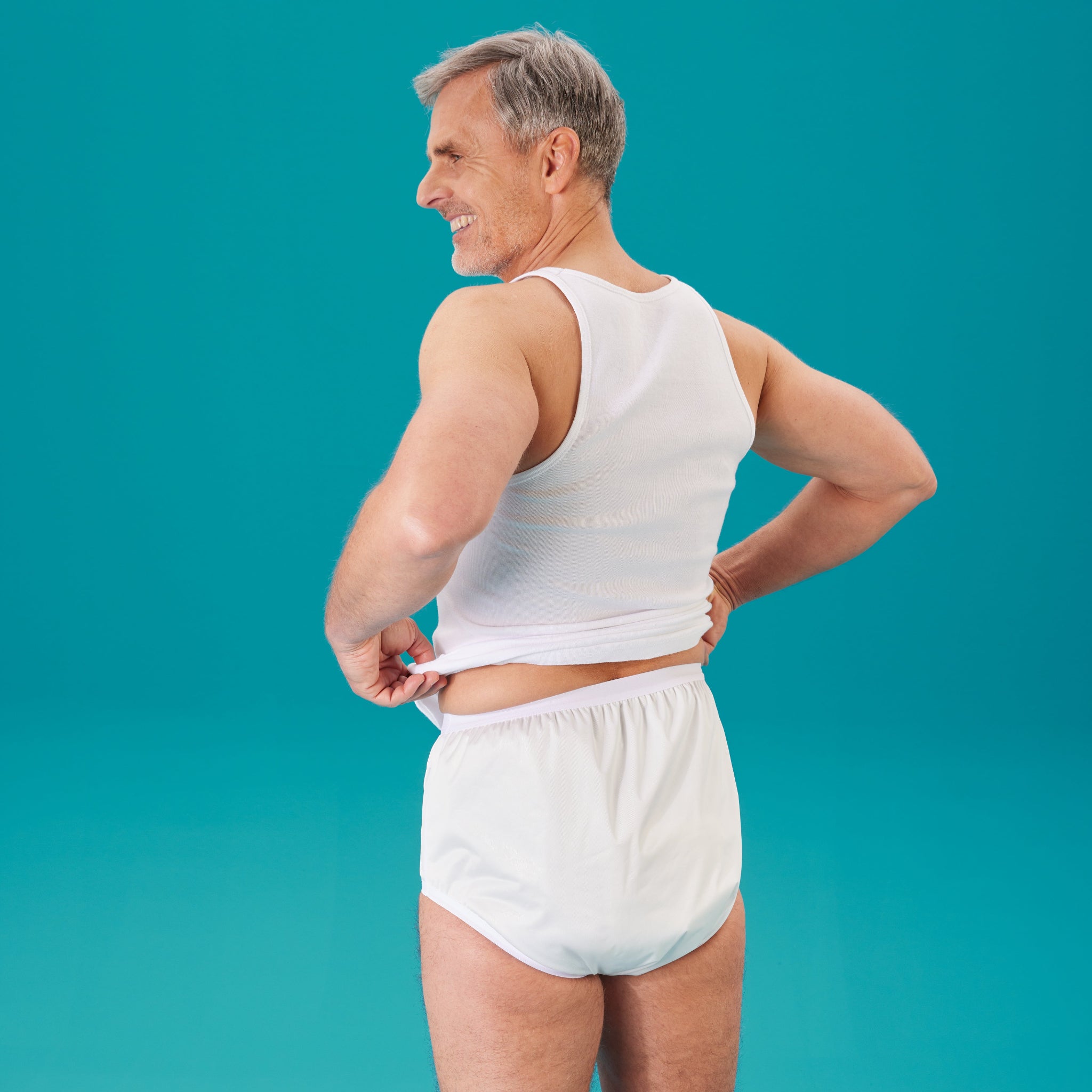 Mann im suprima PU-Slip 1204 in weiss von hinten, er zieht das Oberteil hoch - Rueckenansicht