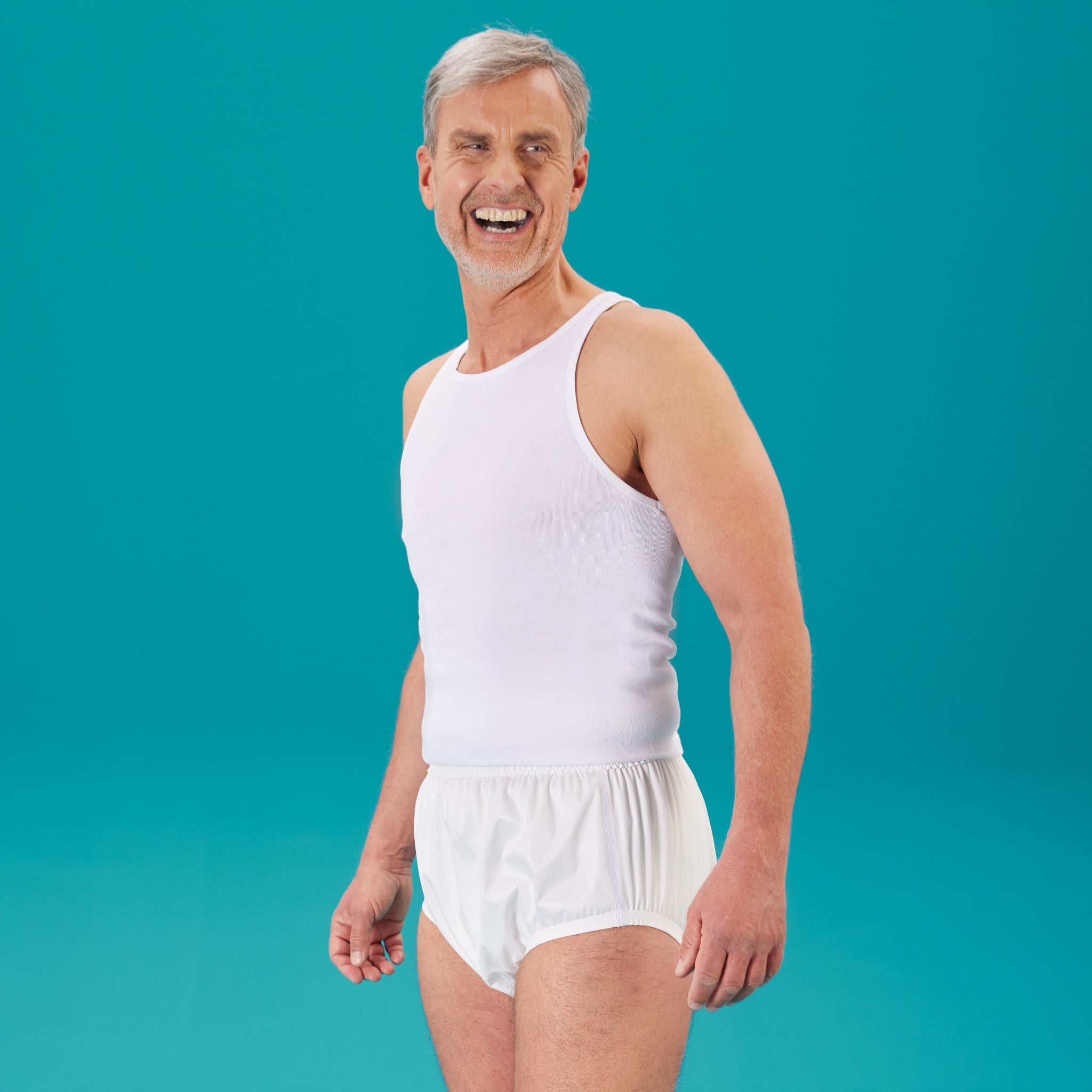 Lachender Mann traegt den suprima PU-Slip 1287 in Weiss mit weissem Traegershirt – Inkontinenzhose